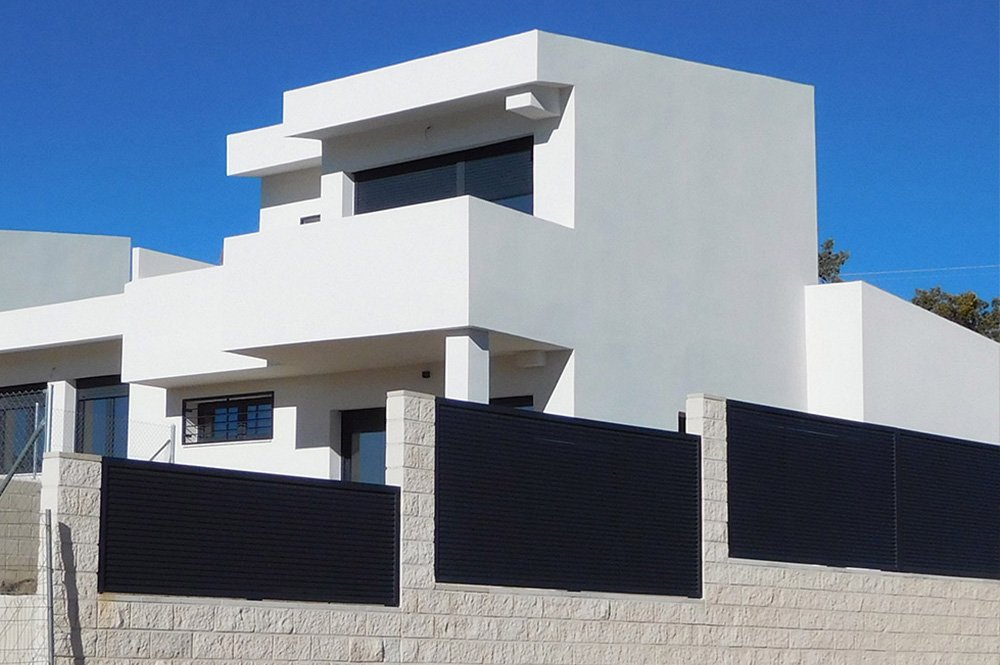 Casa unifamiliar de estilo moderno, de dos pisos dentro de una parcela delimitada por un muro