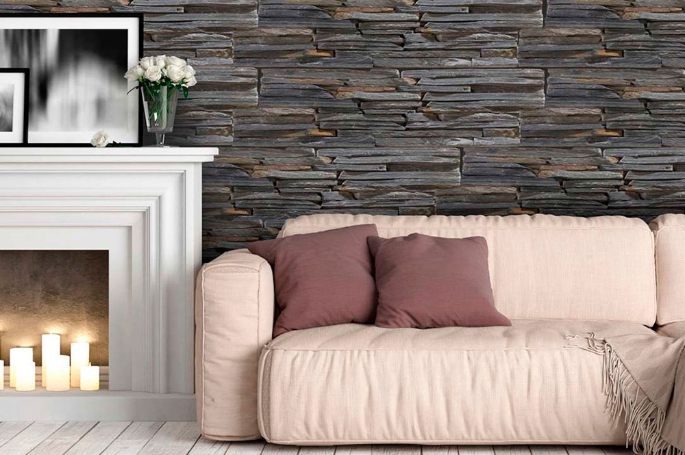 Sofá delante de una pared revestida de placas de piedra, al lado de una chimenea