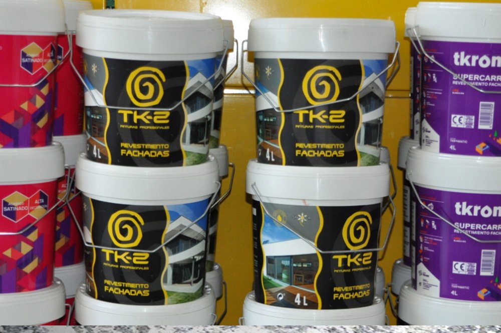 Varios botes de pintura grandes apilados unos encima de otros