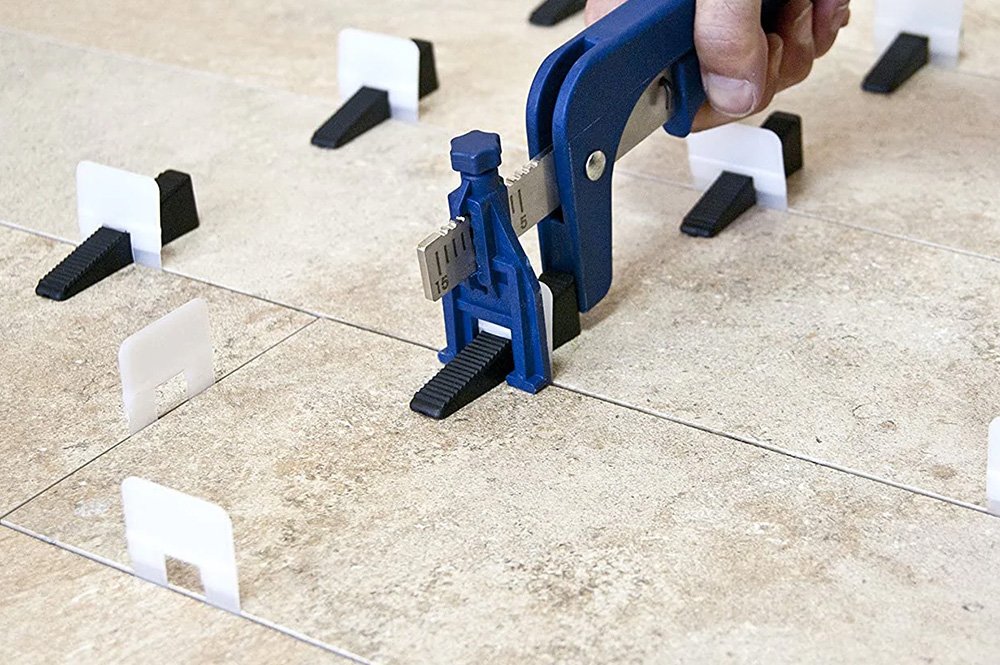 Primer plano de placas de pavimento con un calzo de nivelación midiendo la posición de las mismas