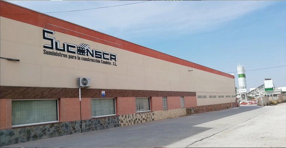 Vista exterior la nave de Suconsca con una pequeña planta de hormigón al fondo